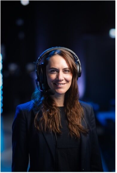 Eventmoderator mit Headset vor Bühnenkulisse bei einem Business Event mit moderner Eventtechnik