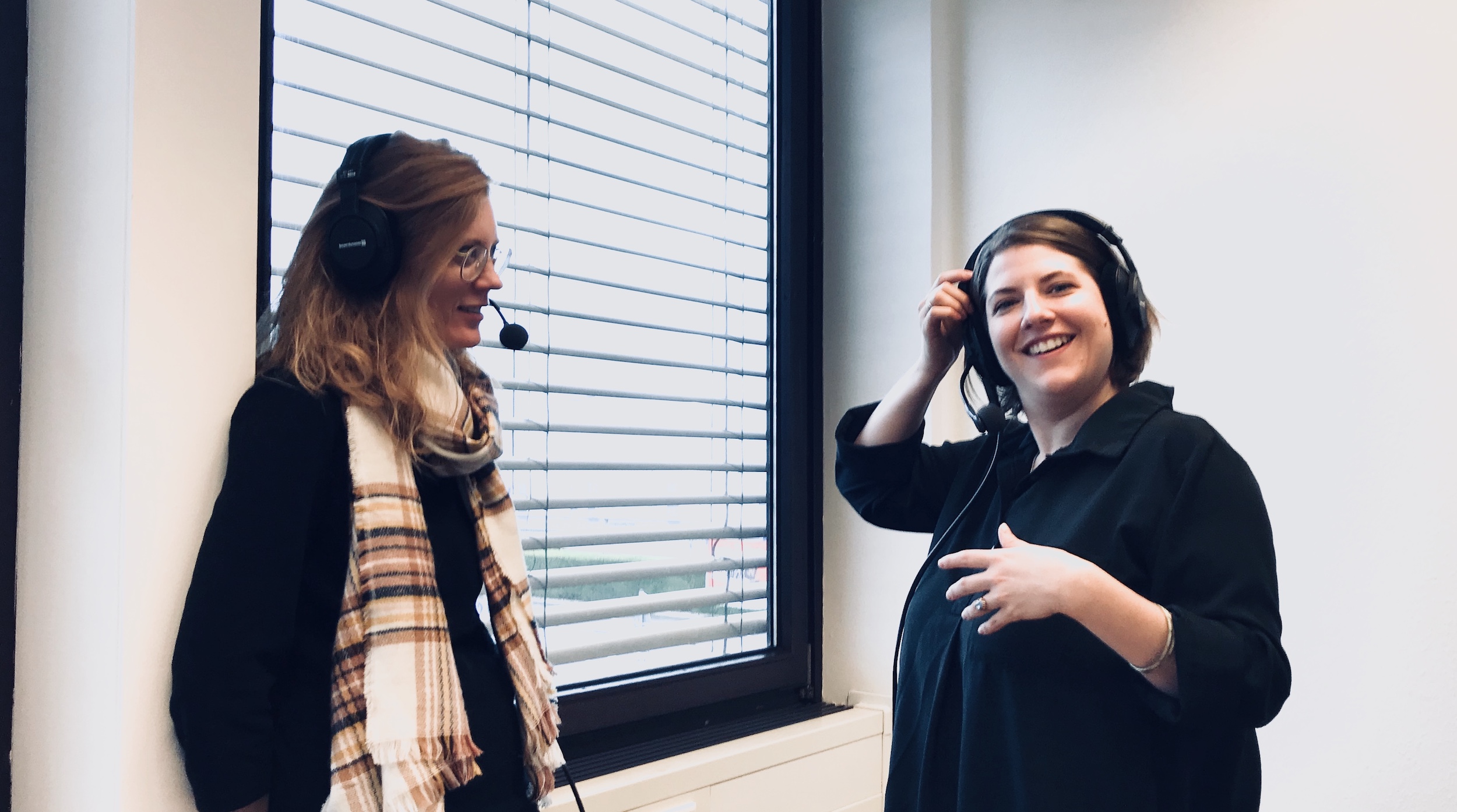 Unser Mitarbeiterin Lia im Gespräch mit Sarah Schäfer. Beide tragen Podcast-Kopfhörer.