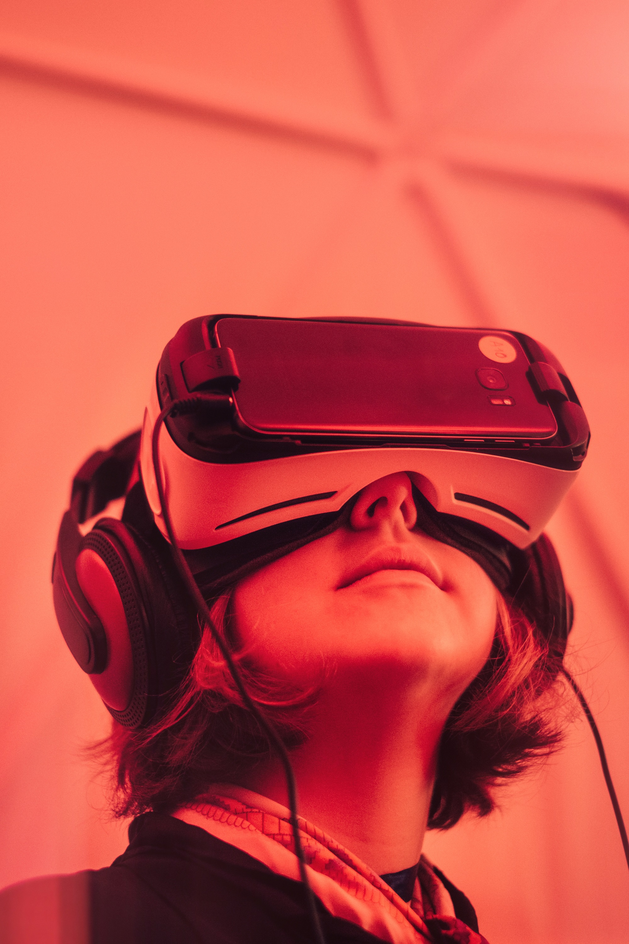 Bild einer Frau, die eine Virtual Reality Brille trägt mit rotem Licht.