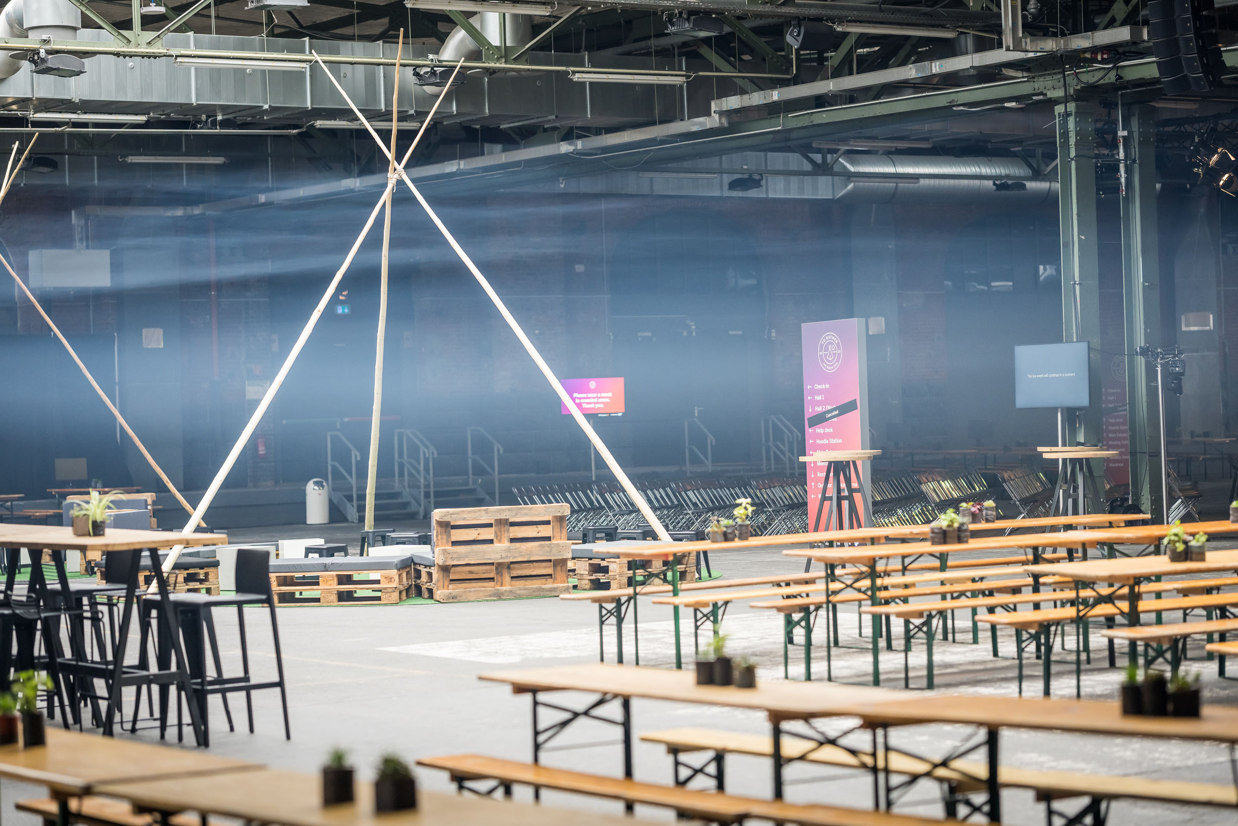Bild des Setups für das Team-Event TO.GATHER SAP Signavio Camp 2023 in der Station Berlin. Tipi-artige Bauten markieren Networkingbereiche.
