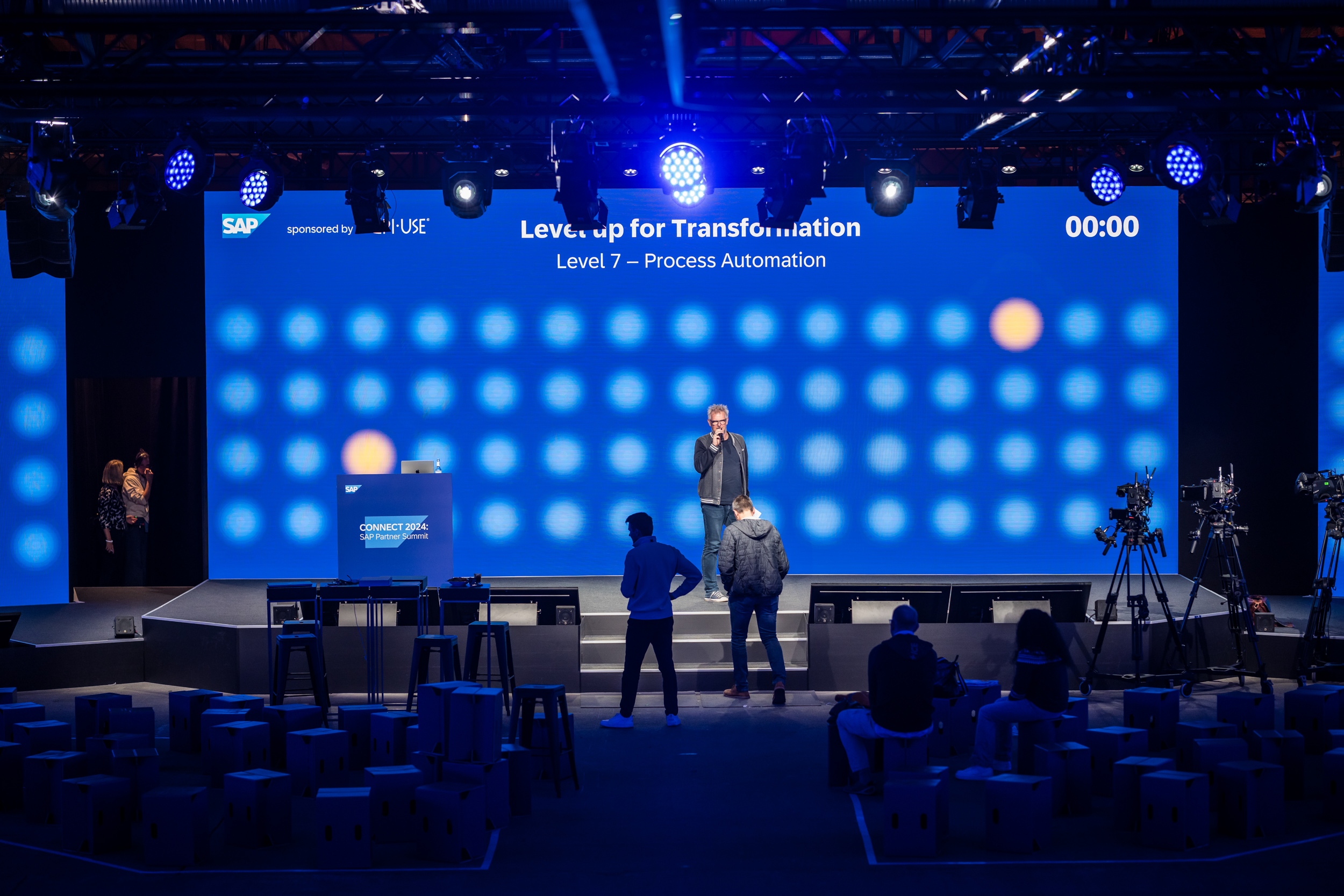 Bühne mit großer LED-Wand und Moderator