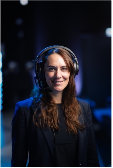 Eventmoderator mit Headset vor Bühnenkulisse bei einem Business Event mit moderner Eventtechnik