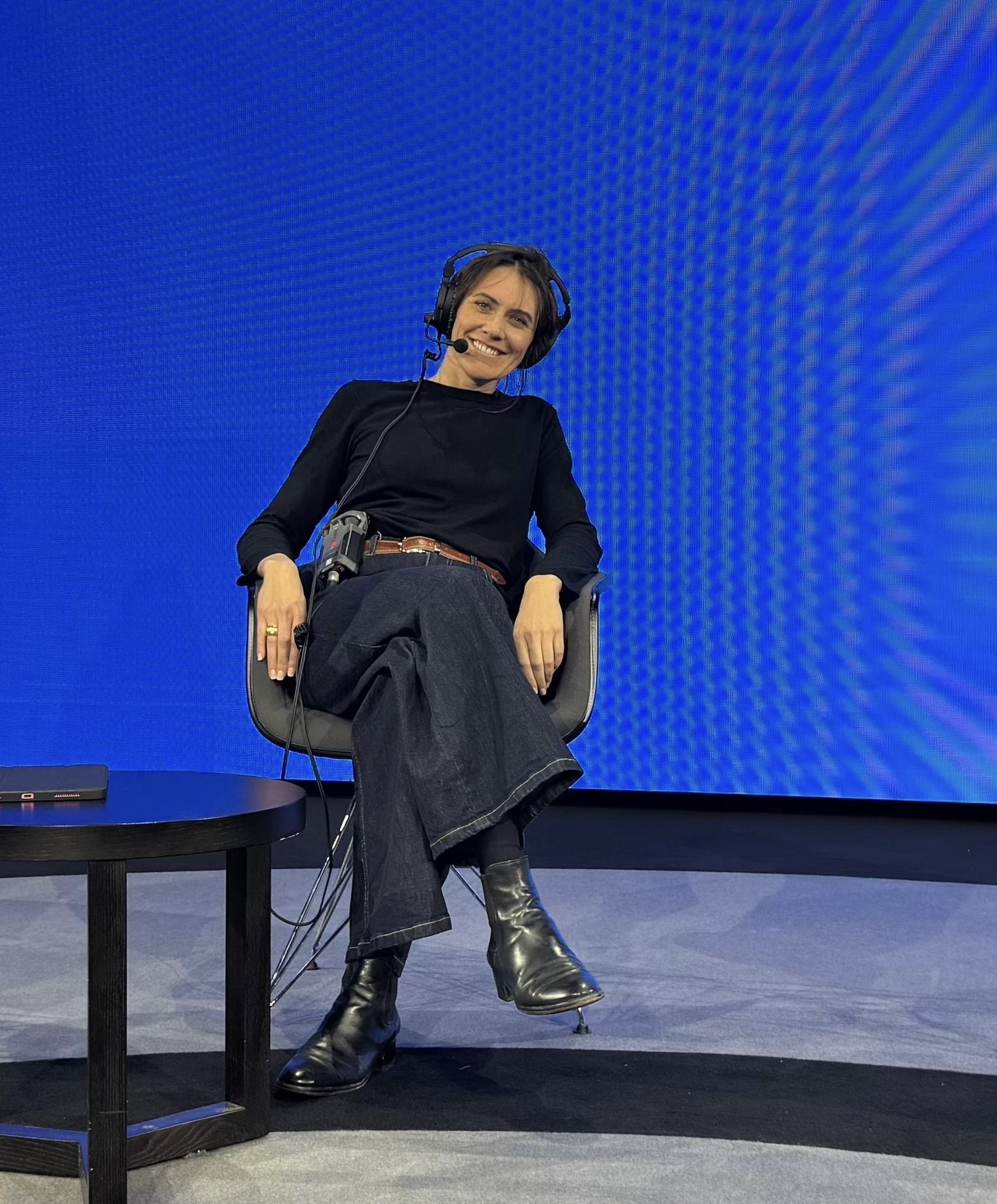 Event moderator on stage in front of LED screen at a conference with modern event production